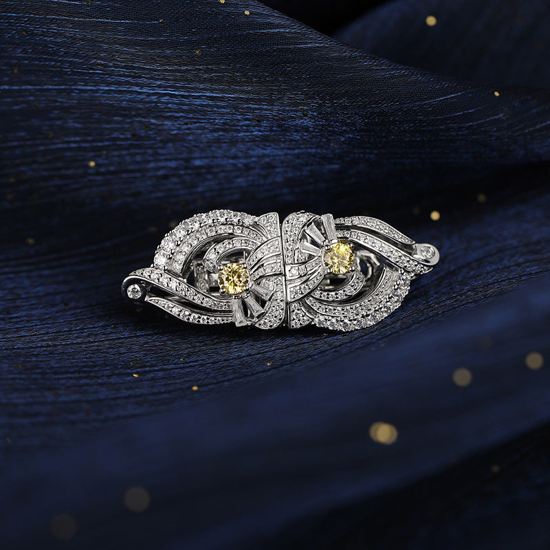 Silver brooch with yellow gemstones on a dark textured background