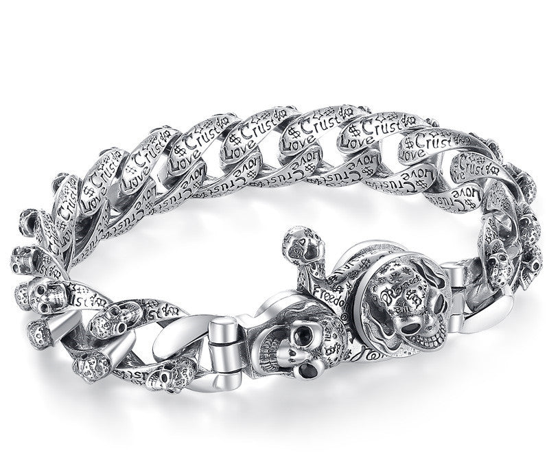 Silver bracelet with skull and anchor designs on a white background
