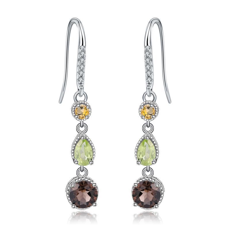 Pair of silver earrings with green, brown, and yellow gemstones on a white background