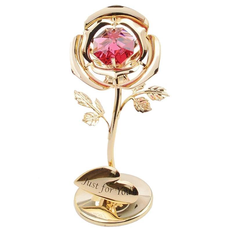 Gold rose with a pink gemstone on a white background