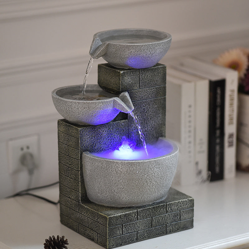 Fountain with three bowls and LED lights on a surface
