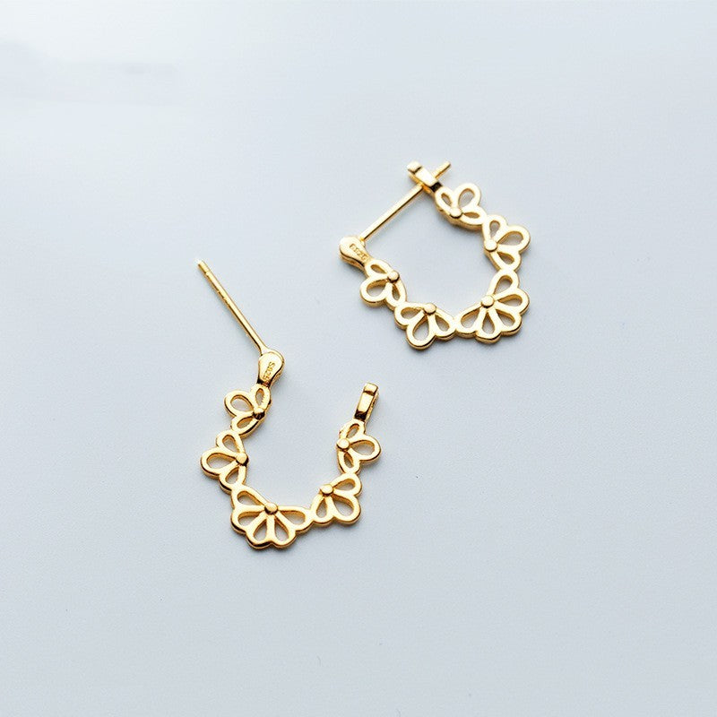 Gold hoop earrings on a light gray background
