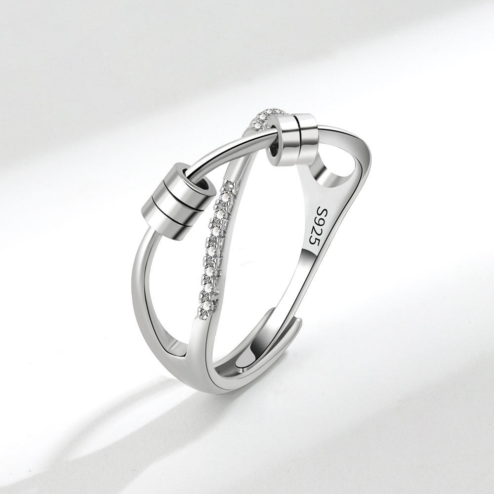 Silver ring with diamond accents on a light gray background