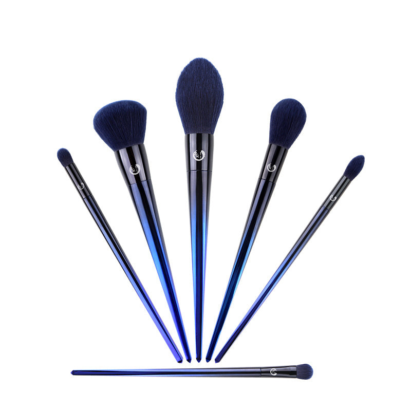 Set of makeup brushes with blue handles and black bristles on a white background