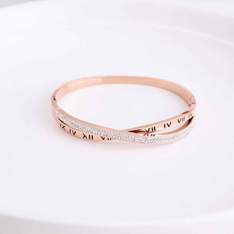 Rose gold bracelet with Roman numeral design on a white background