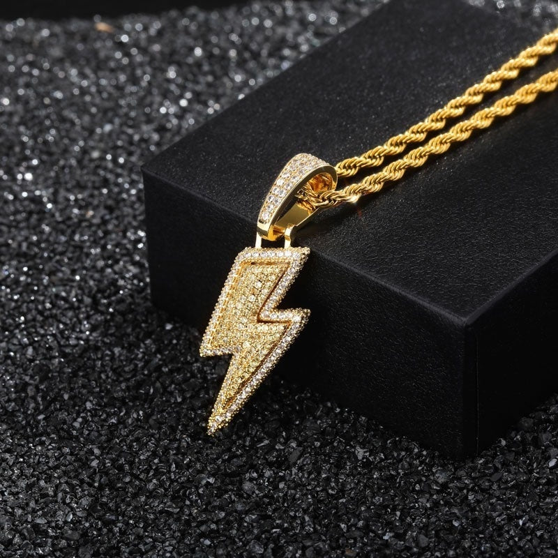Gold lightning bolt pendant on a black stand with a dark textured background