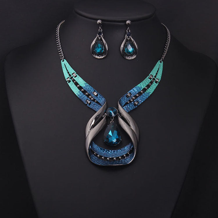 Jewelry set with necklace and earrings featuring blue and silver design on a black background