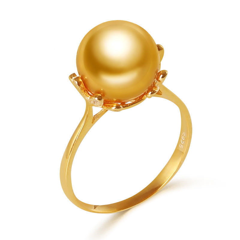 Gold ring with a large pearl on a white background