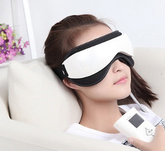 Person wearing a white eye mask with black straps, holding a device, on a light background.