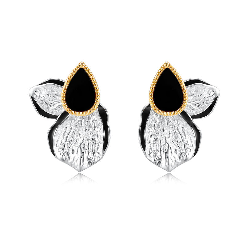 Pair of earrings with black teardrop stones and gold accents on a white background