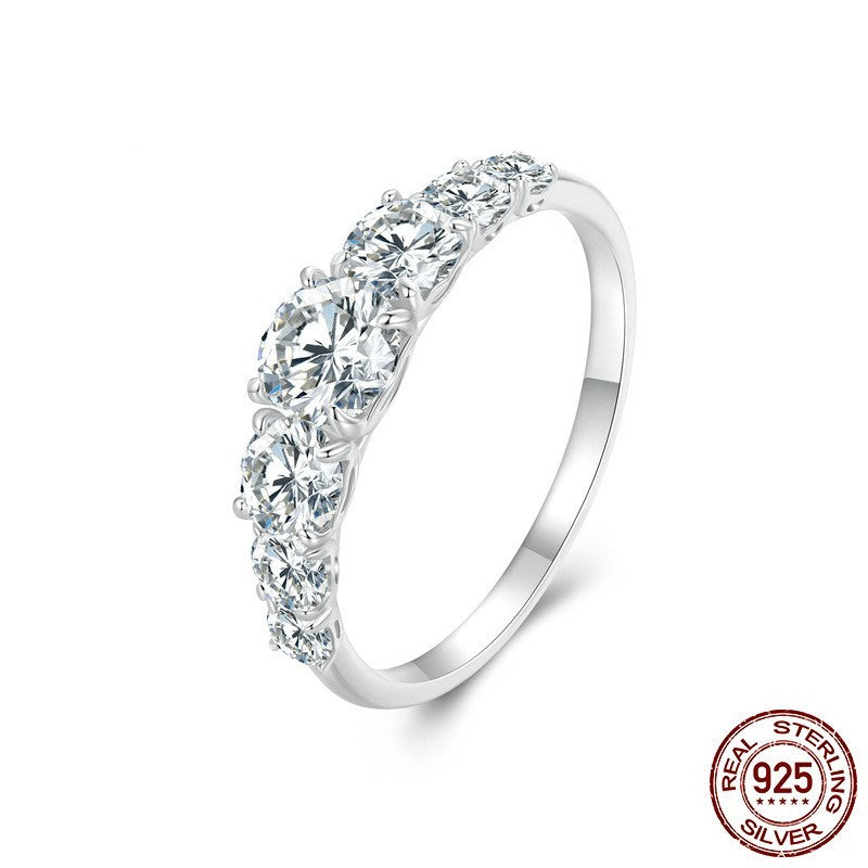 Silver ring with clear gemstones on a white background, featuring 'Real Sterling Silver' stamp.