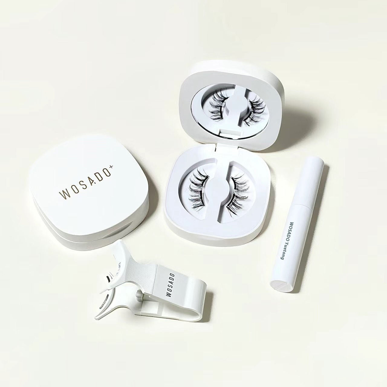 Set of false eyelashes with applicator and case on a white background