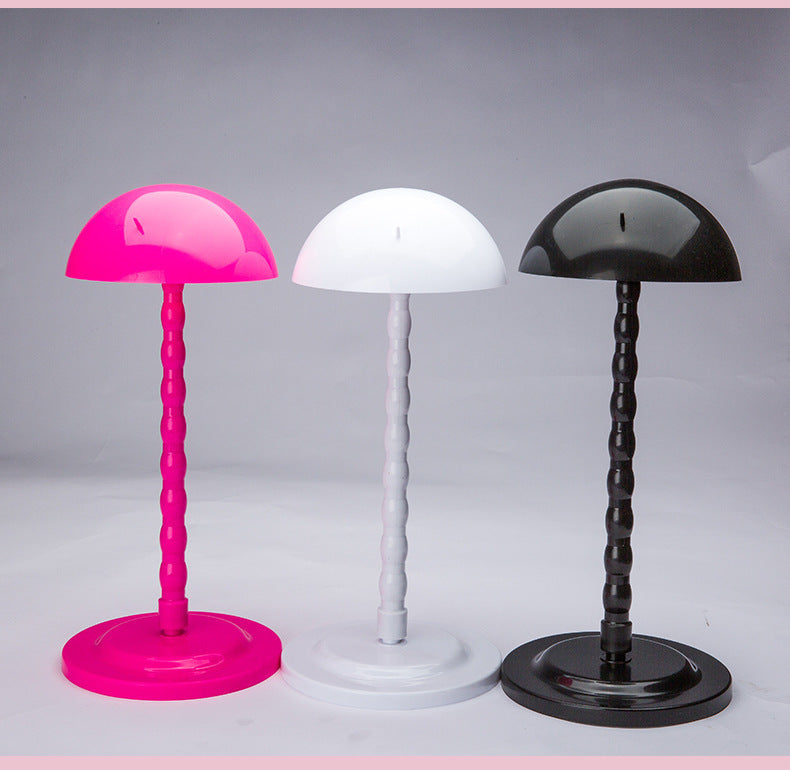 Three colorful table lamps with pink, white, and black bases on a gray background
