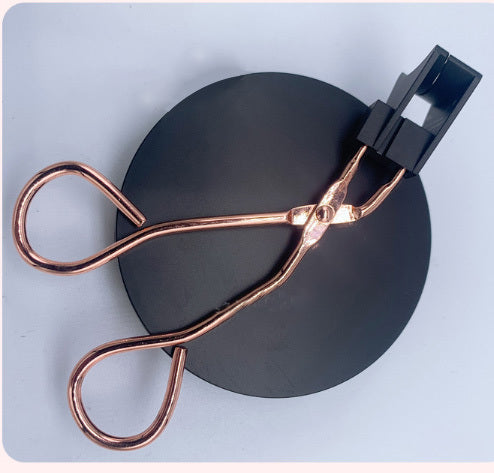 Eyelash extension set with tweezers in a black and gold box on a pink background