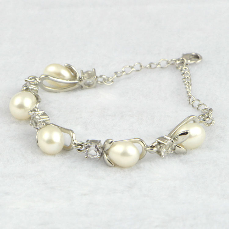 Pearl bracelet with silver chain on a light gray background