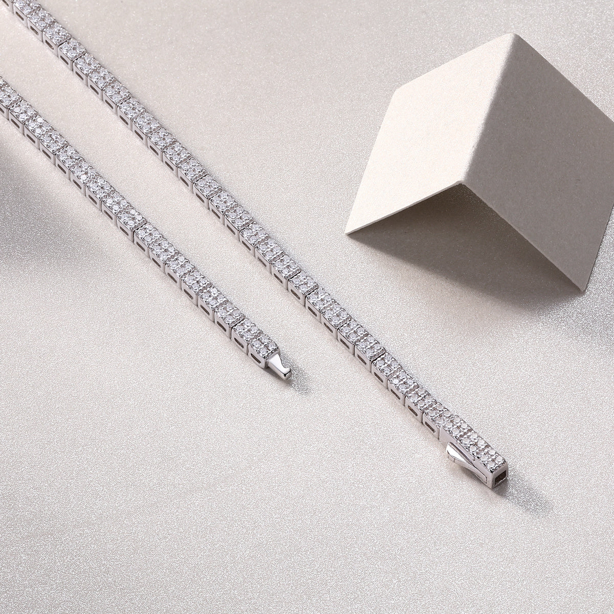 Silver bracelet with diamond accents on a light gray surface
