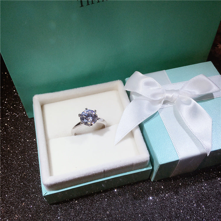 Silver ring with a purple gemstone in a Tiffany & Co. box.