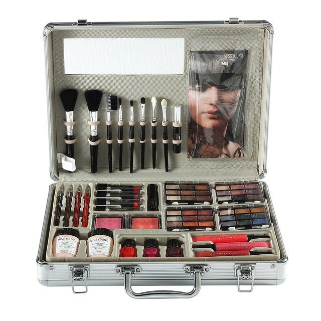 Makeup set with brushes, palettes, and other tools in an open case on a white background