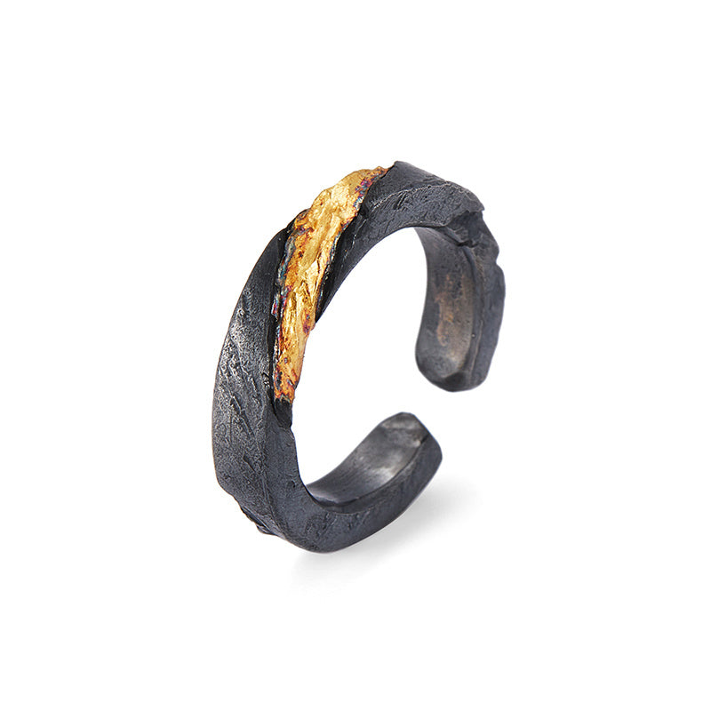 Black textured ring with gold and purple accents on a white background