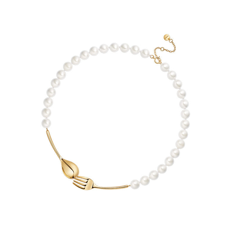 Pearl necklace with a gold leaf-shaped clasp on a white background