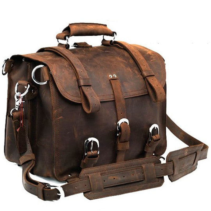 Brown leather satchel bag with multiple straps on a white background