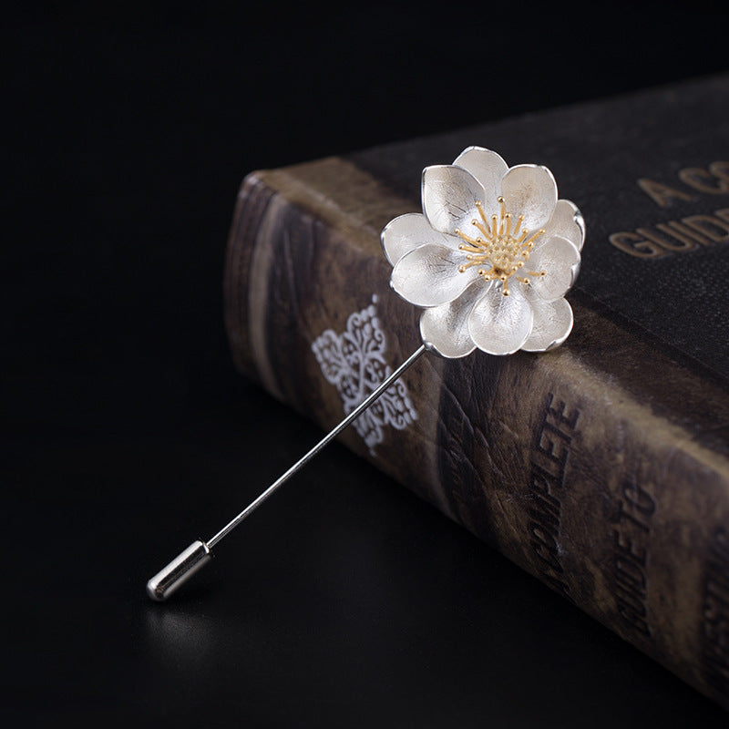 Floral brooch on an old book with a dark background