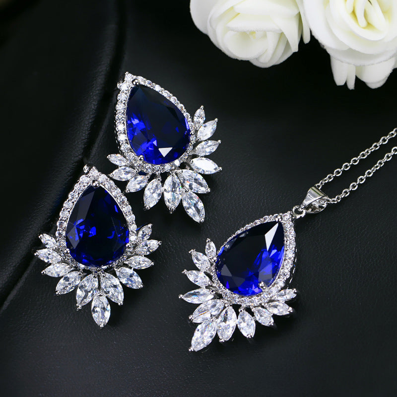 Jewelry set with blue teardrop stones on a black background
