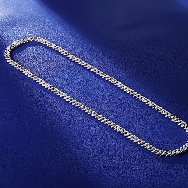Silver chain necklace on a blue fabric background