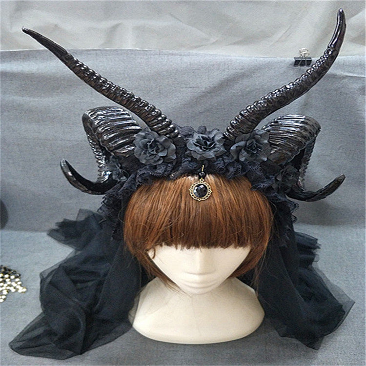 Black horned headpiece with flowers on a mannequin head against a gray background