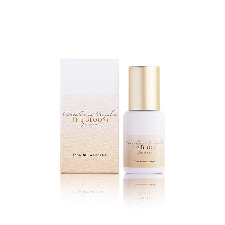 Cosmetic bottle and packaging of 'The Bloom' by Comedellaria Mazalina on a white background