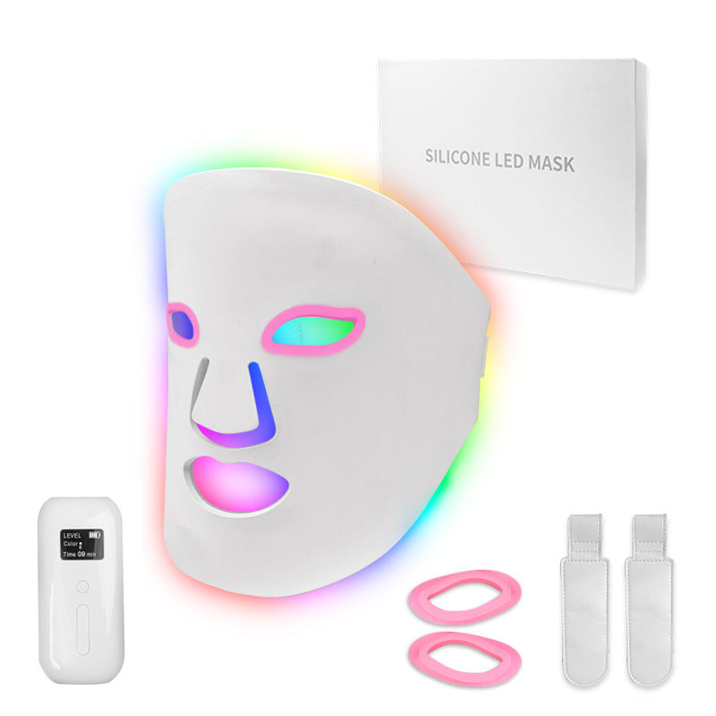 Silicone LED mask with colorful light display, remote control, and accessories on a white background