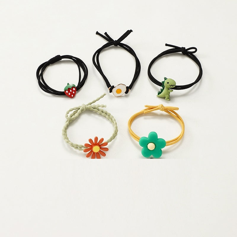 Set of five hair ties with colorful charms on a white background