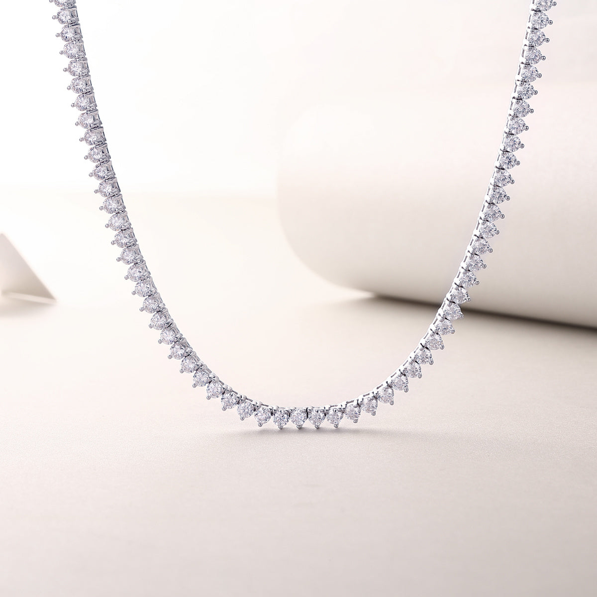 Dainty silver necklace with clear stones on a light background