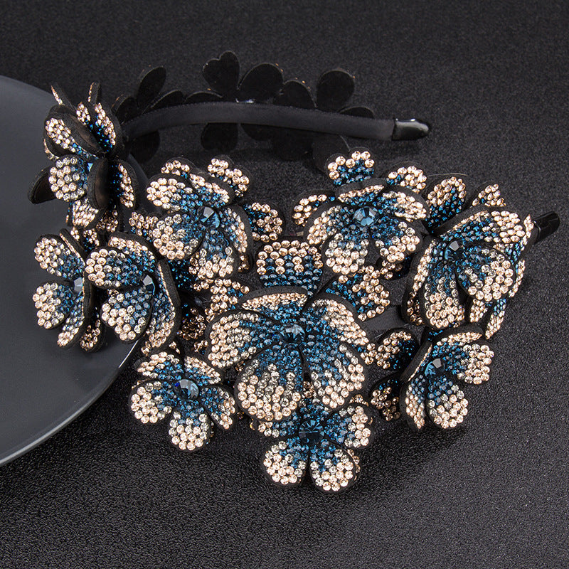Decorative headband with blue and silver floral embellishments on a black background