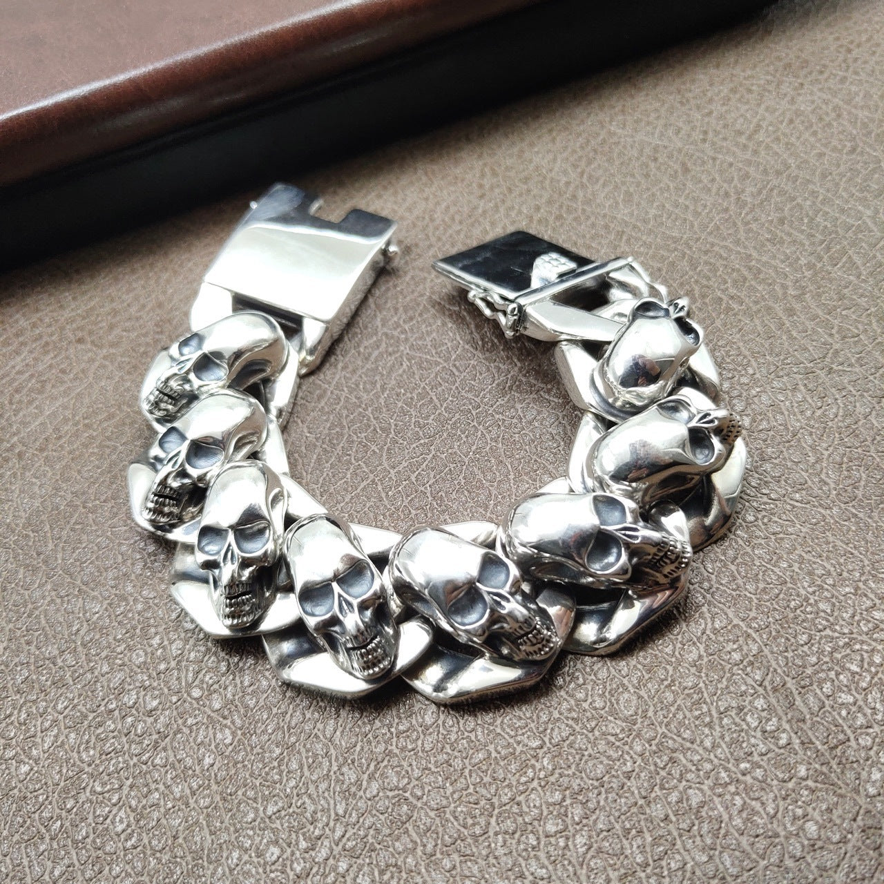 Silver skull-themed bracelet on a textured surface