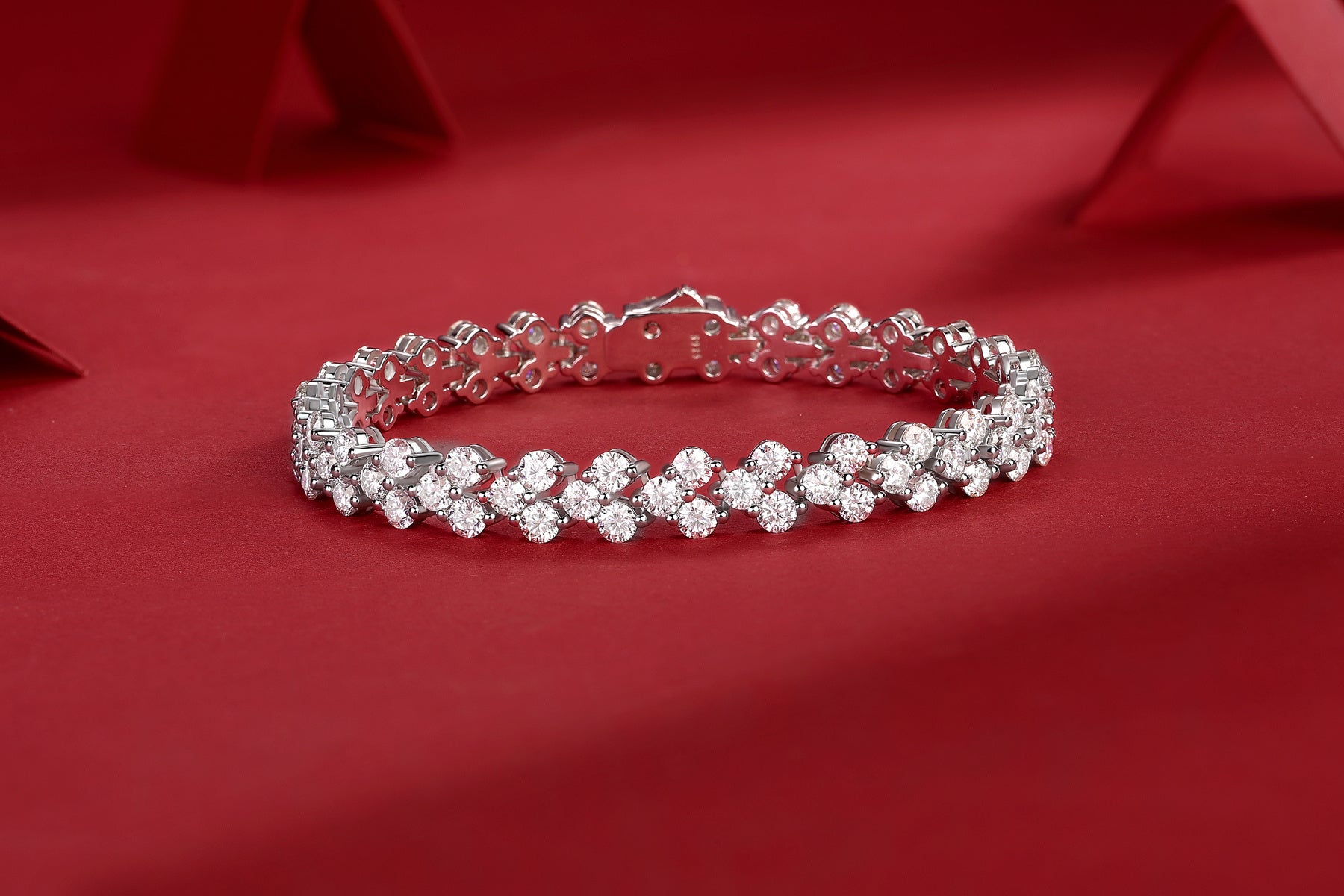 Silver bracelet with clear stones on a red background