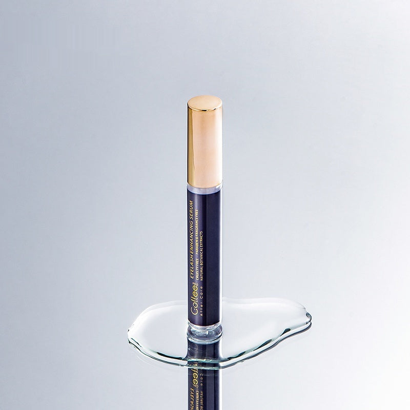 Cosmetic serum bottle with gold cap on a reflective surface