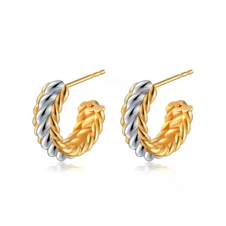 Pair of gold and silver hoop earrings on a white background