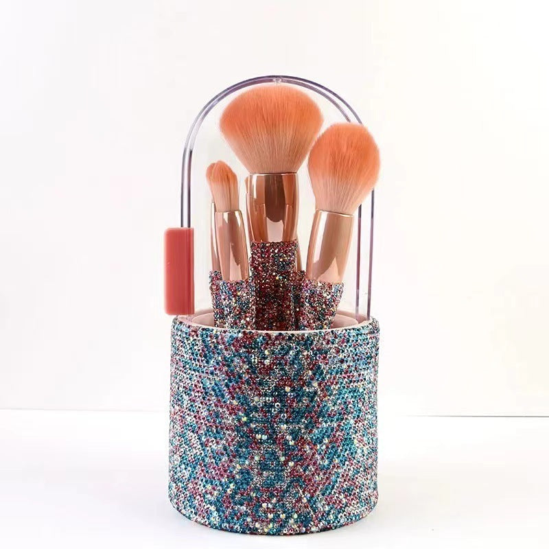 Set of makeup brushes in a multicolored holder on a white background