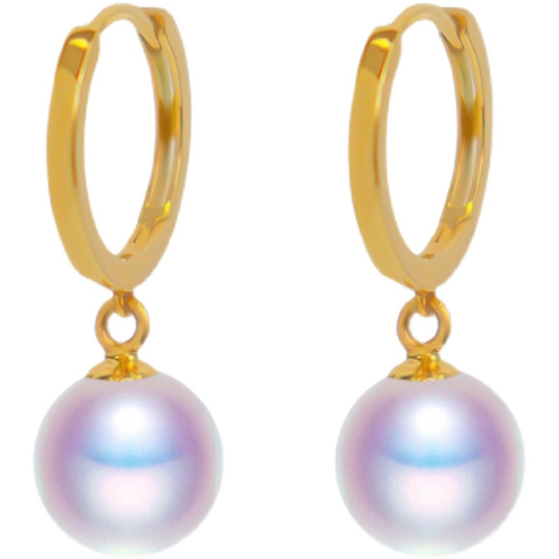 Gold hoop earrings with pearl drops on a white background