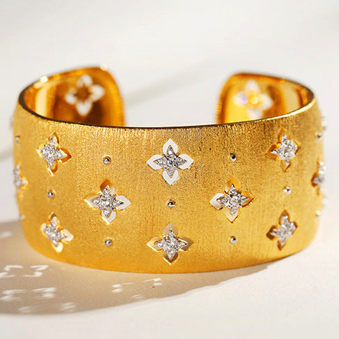 Gold bracelet with star-shaped diamond embellishments on a light background