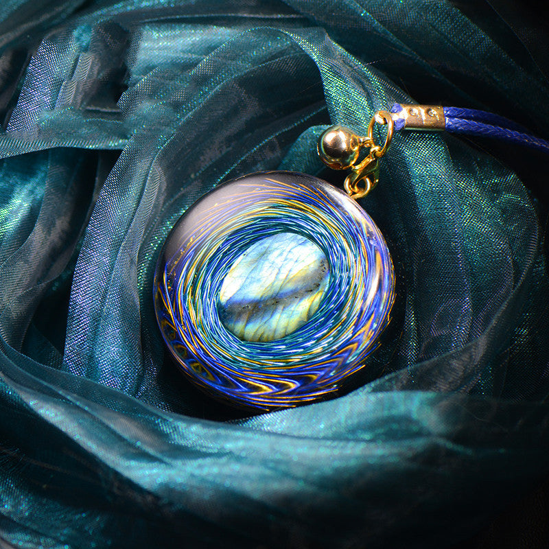 Necklace with a colorful pendant on a teal fabric background