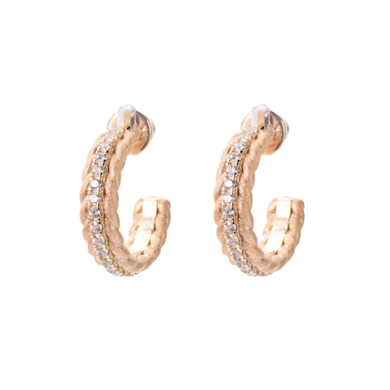 Rose gold hoop earrings with embedded stones on a white background