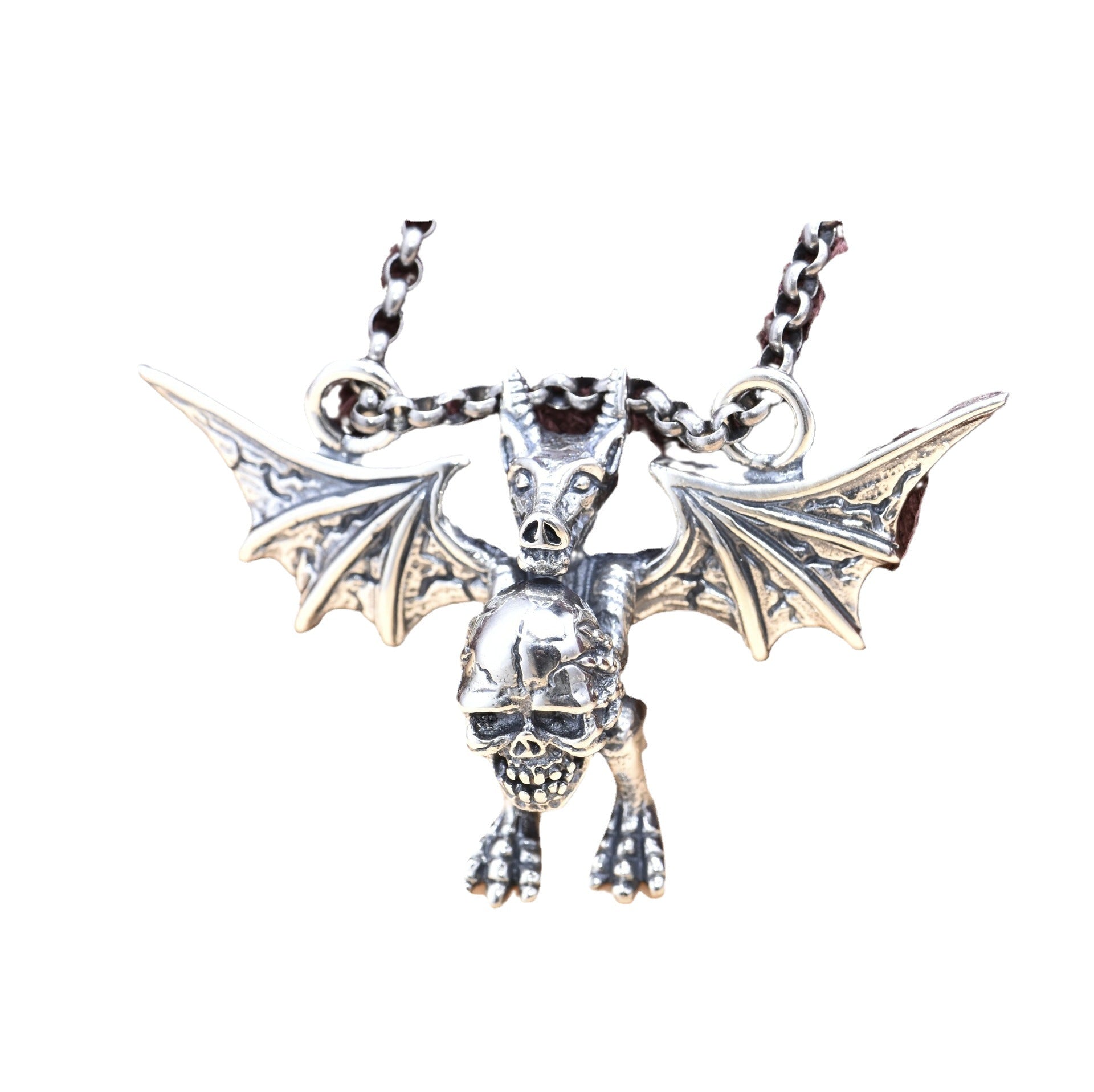 Silver bat pendant with wings spread on a white background