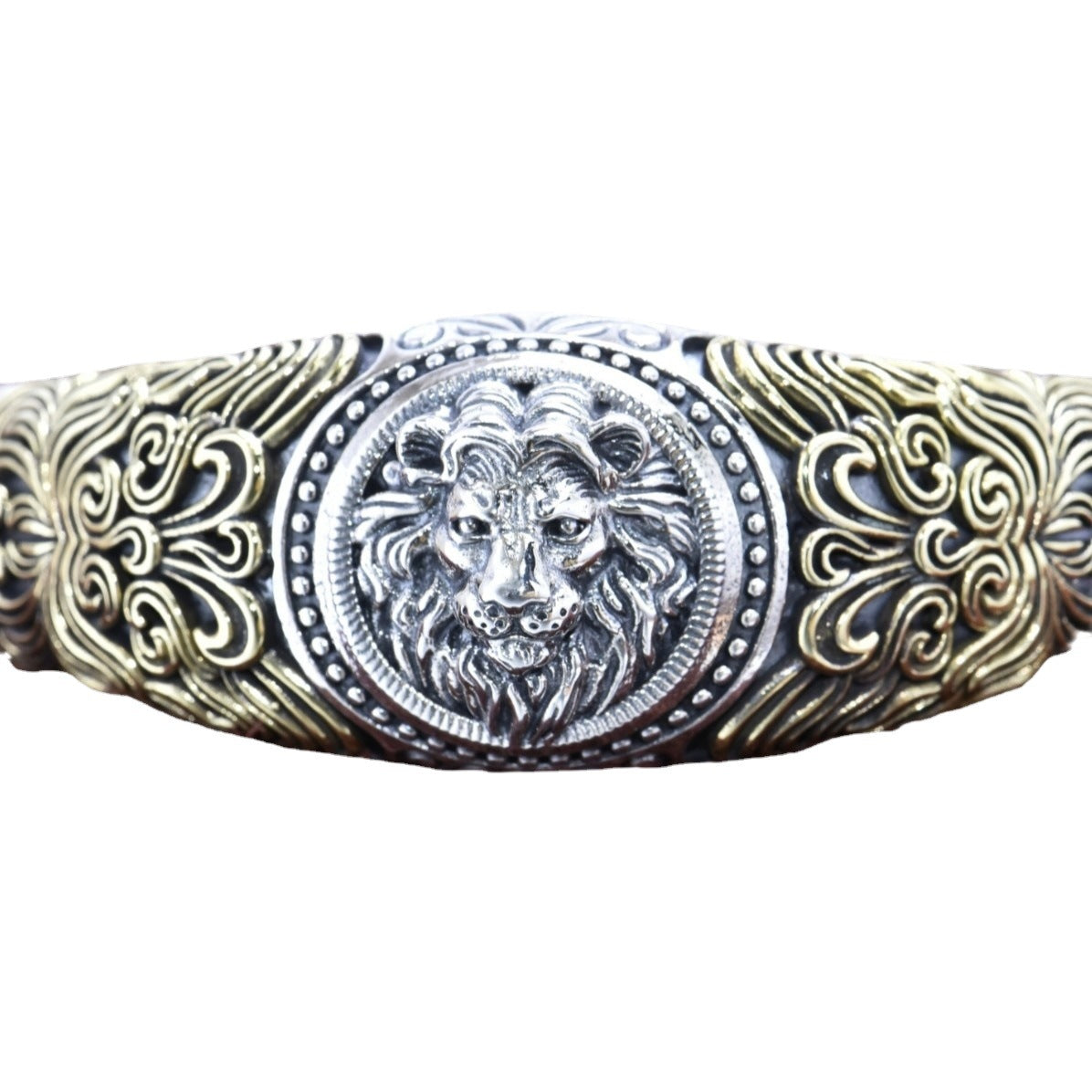Decorative belt buckle with lion emblem and intricate patterns on a white background