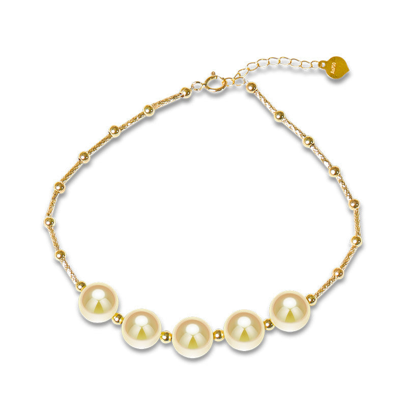 Gold bracelet with pearls on a white background