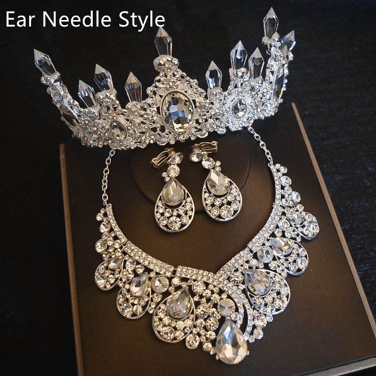 Silver jewelry set with necklace, earrings, and tiara on a dark background