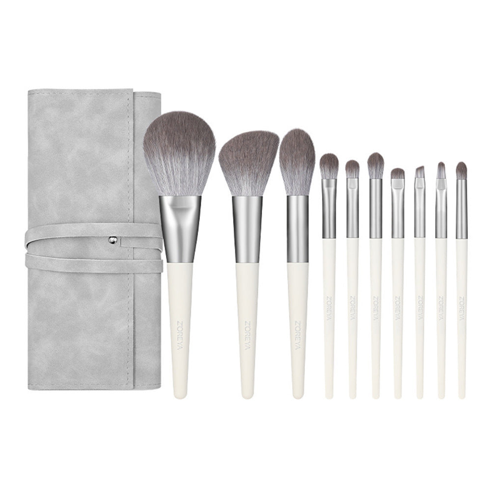 Set of makeup brushes with a gray case on a white background