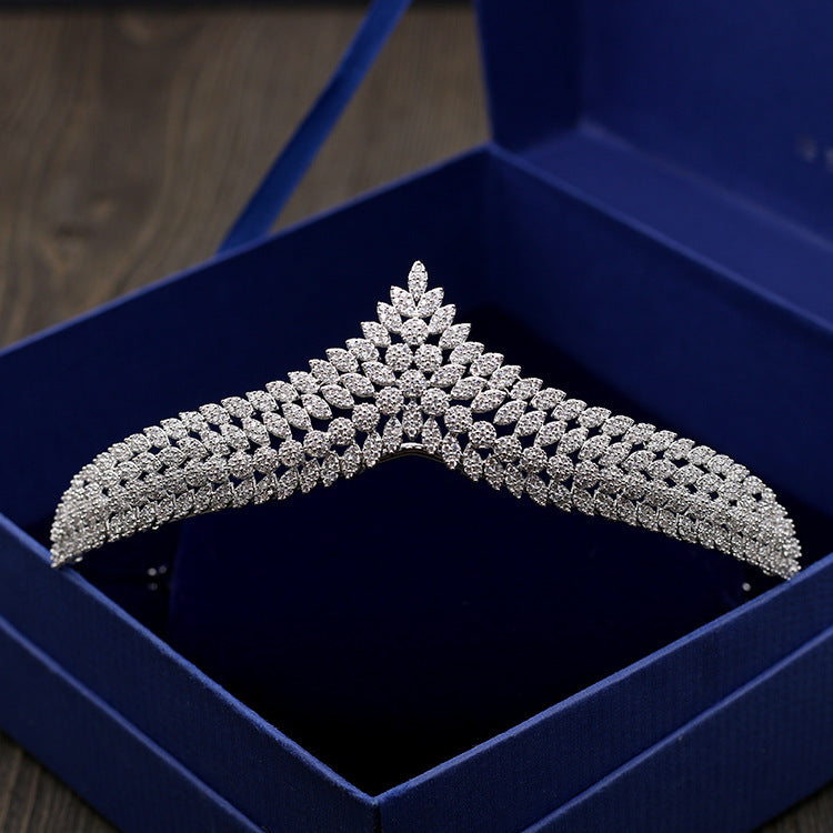 Silver decorative hanger in a blue box on a wooden surface
