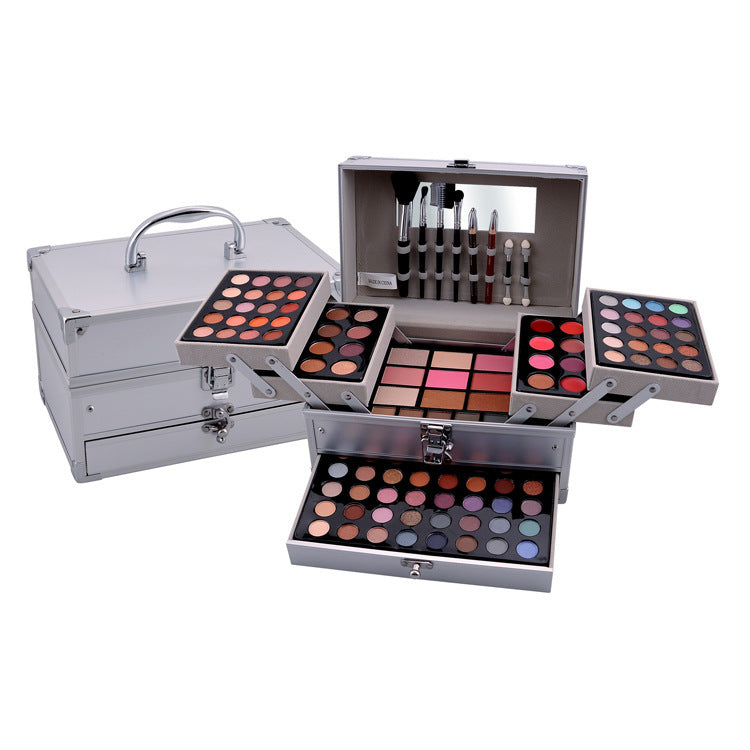 Makeup set with multiple palettes and brushes in a silver case on a white background